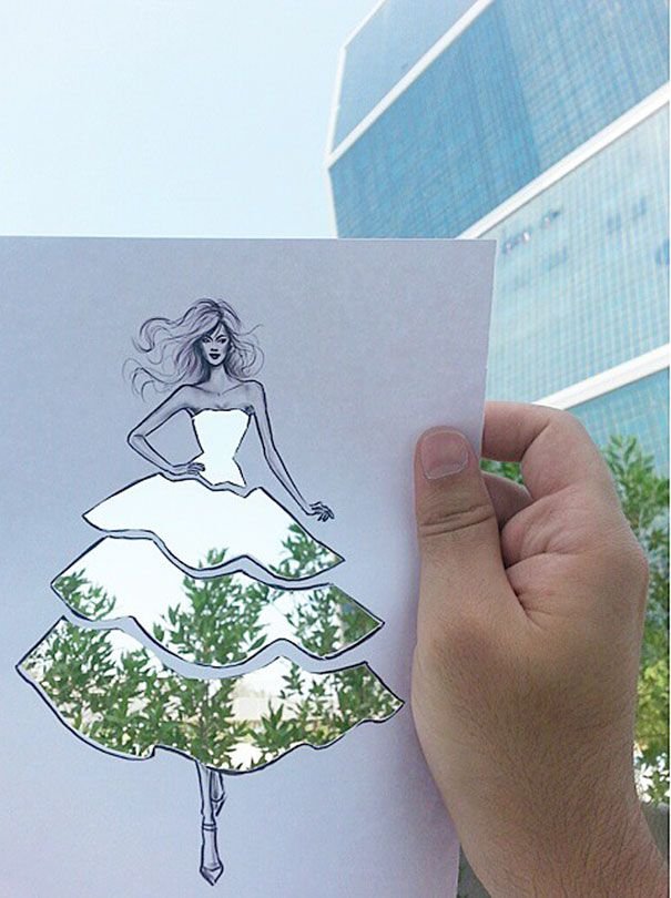 Ilustrator mody wykańcza swoje powycinane sukienki chmurami oraz budynkami